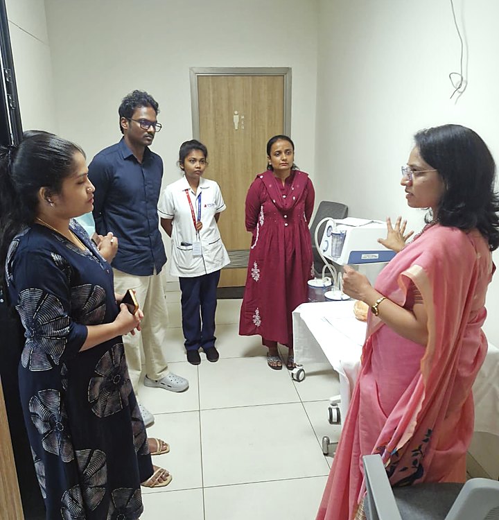Dr. Megha Kadam briefing clinical staff beside an examination trolley